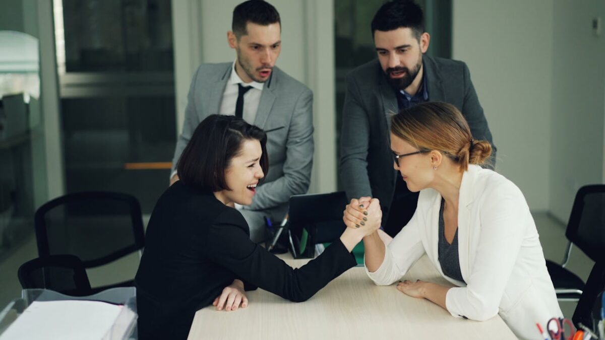 Colleagues engaging in a spirited arm wrestling contest at work, showcasing teamwork and competition.
